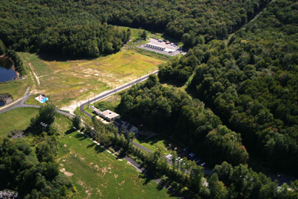 Aerial view of the Yankee Rowe site, with ISFSI down a short road from the control building and nestled in the trees and foothills